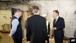 Britain's Prime Minister David Cameron (r) visits a looted Liddell supermarket in Salford, England, Aug. 12, 2011