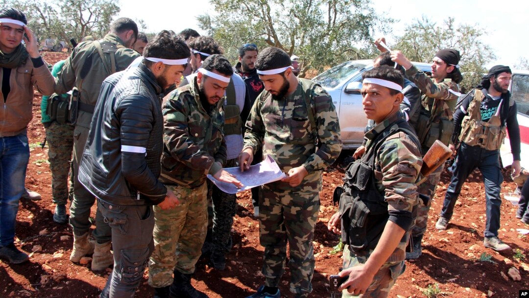 Turkey-backed Free Syrian Army fighters advance in Der Mismis village in the southeast portion of Afrin, Syria, March 13, 2018. Turkish troops and allied Syrian opposition fighters have intensified attacks on the Syrian Kurdish-held town of Afrin.