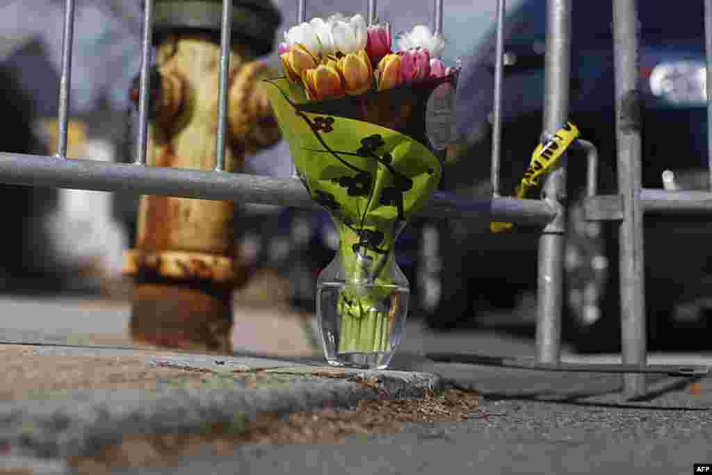 A bouquet of flowers is left on a sidewalk during the funeral service for the late singer Whitney Houston near the New Hope Baptist Church, in Newark, New Jersey, February 18, 2012. (REUTERS)