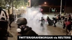 Protesters confront with the police near an Immigration and Customs Enforcement centre in Portland, Oregon, Aug. 20, 2020, in this still image from a video obtained from social media.