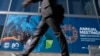 A delegate walks by an IMF banner, during the World Bank/IMF Annual Meetings at the International Monetary Fund (IMF) headquarters in Washington, Oct. 21, 2024. 