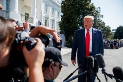 President Donald Trump talks to reporters on the South Lawn of the White House, Aug. 9, 2019, in Washington.