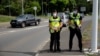 Des gendarmes sur la route de Saint Michel, le jour du vote pour le référendum sur l'indépendance, au Mont Dore, sur le territoire français de Nouvelle-Calédonie, le 12 décembre 2021.