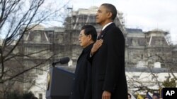 President Barack Obama and Chinese President Hu Jintao stand quietly during an official arrival ceremony for Hu at the White House, 19 Jan 2011.