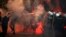 Montenegrin police officers are engulfed in smoke and flames as opposition supporters hurl torches toward them during a protest in front of the parliament building in Podgorica, Montenegro, Oct. 24, 2015.