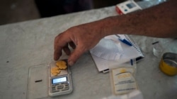 FILE - A gold miner weighs his weekly production at an illegal mine in the Amazon jungle, in the Itaituba area of Para state, Brazil, Aug. 22, 2020. 