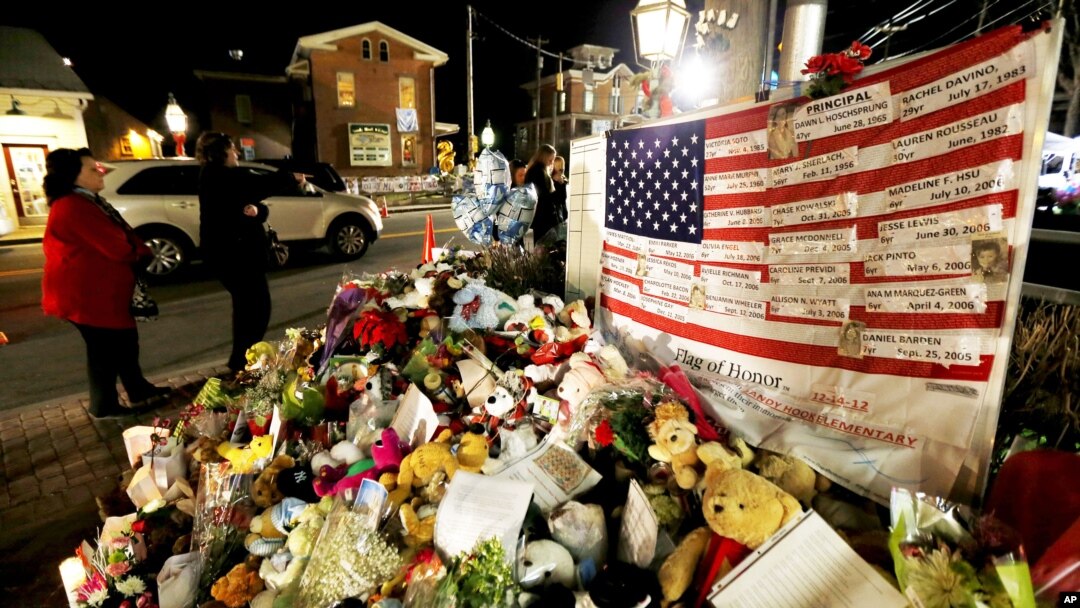 Bendera Amerika dan daftar korban penembakan massal menghiasi sudut kota Newtown, Connecticut (20/12). (Foto: AP)