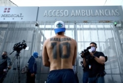 Un fanático del futbolista argentino Diego Maradona se encuentra afuera de la clínica donde fue operado de un hematoma subdural, según su médico personal, en Olivos.