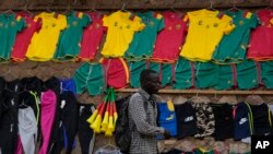 FILE — A Cameroonian walks past a store selling Indomitable Lions merchandise in Yaonde.