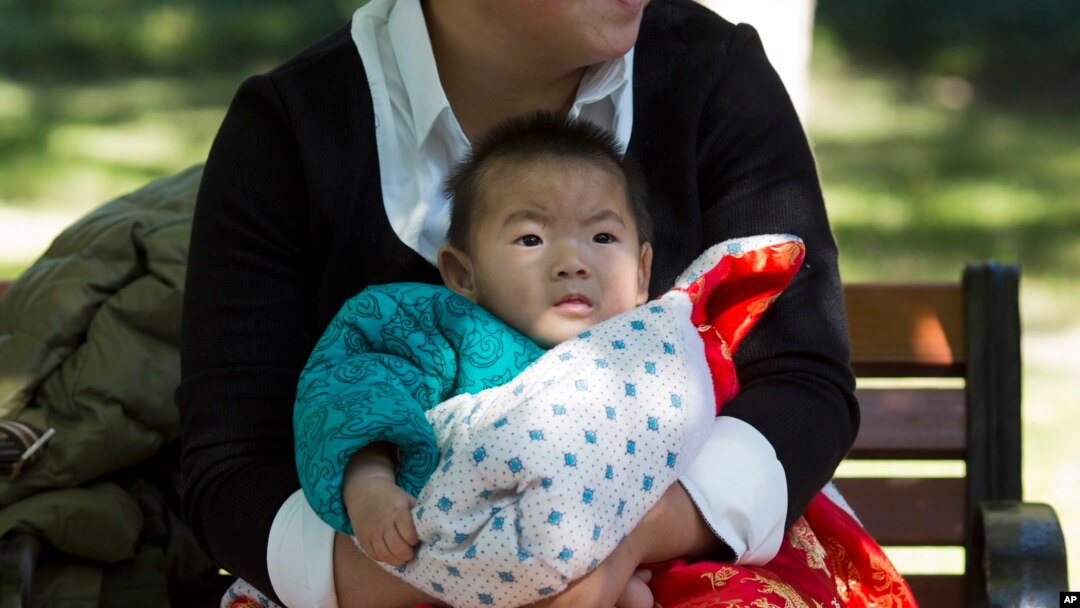 FILE - A child is wrapped up against the cold at a park in Beijing, China, Oct. 30, 2015.