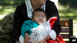 FILE - A child is wrapped up against the cold at a park in Beijing, China, Oct. 30, 2015.