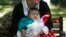 FILE - A child is wrapped up against the cold at a park in Beijing, China, Oct. 30, 2015.