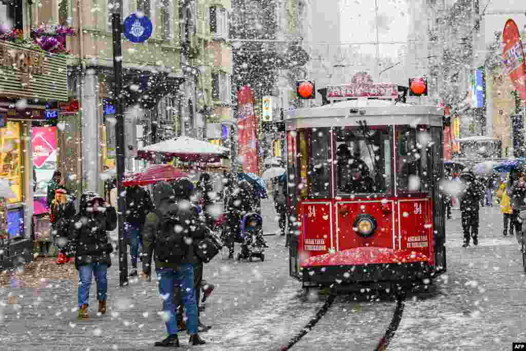 A tram runs under the falling snow along Istiklal Avenue, in Istanbul, Turkey.