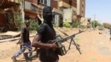 FILE — A member of the Sudanese Armed Forces, SAF, looks on as he holds his weapon in the street in Omdurman, on March 9, 2024. UNICEF says ongoing fighting between the nation's army and the RSF has led to death of thousands and is causing famine. 