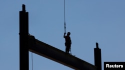 Un miembro del sindicato Ironworkers Local 7 instala vigas de acero en un edificio de gran altura en construcción durante una ola de calor de verano en Boston, Massachusetts, EE. UU., 30 de junio de 2021.