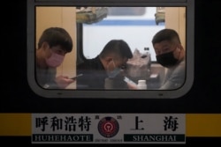 Passengers wearing masks are seen on a train at Shanghai railway station in Shanghai, China, Jan. 21, 2020.