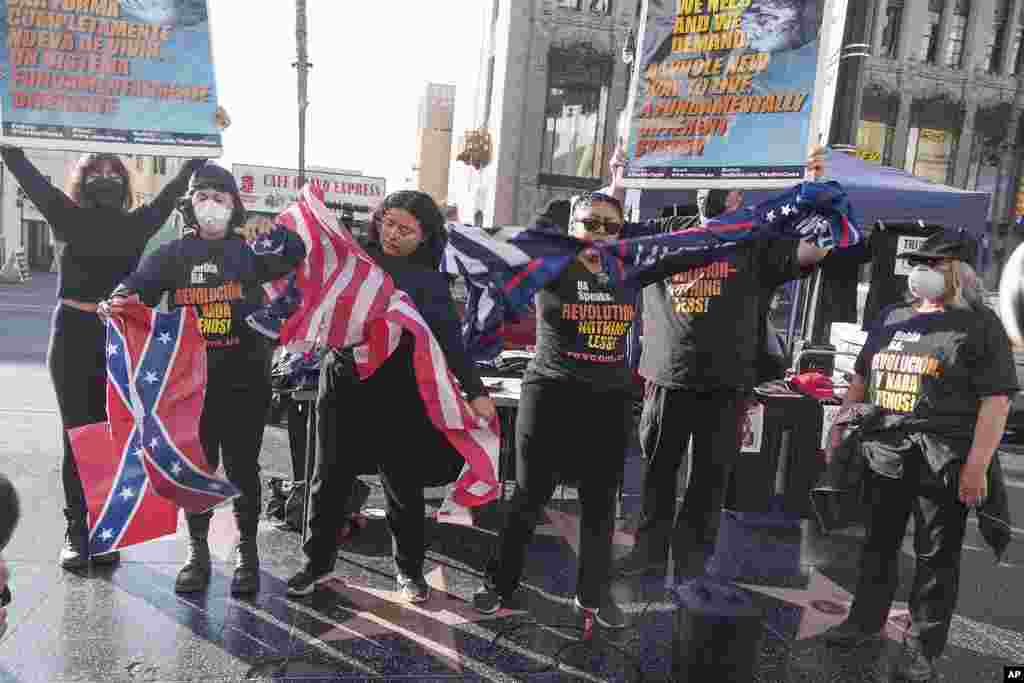 Members of the Revcom Corps for the Emancipation of Humanity rip the U.S. flag, the Confederate flag, and the Trump flag at Donald Trump's star on the Hollywood Walk of Fame in Los Angeles, Jan. 20, 2025.