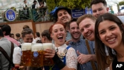 Una camarera posa con los invitados en la carpa de cerveza Hofbraeuhaus el primer día del 189º festival de cerveza 'Oktoberfest' en Múnich, Alemania, el sábado 21 de septiembre de 2024.