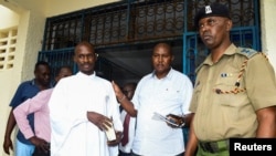 Detectives escort Ezekiel Ombok Odero at the police headquarters in Mombasa