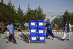 FILE - Independent Election Commission workers carry ballot boxes to be taken to a counting center in Kabul, Oct. 2, 2019.