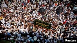 ຜູ້ຄົນພາກັນໄປຫາມໂຮງສົບຂອງຜູ້ໄດ້ຮັບເຄາະຮ້າຍຈາກເຫດໄຟໄໝ້ ໃນພິທີສົ່ງສະການຢຸ່ທີ່ປ່າຊ່າ Yaeway ໃນນະຄອນຢ້າງກຸ້ງຂອງມຽນມາ ໃນວັນທີ 2 ເມສາ 2013. 