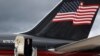 El expresidente de EEUU Donald Trump aparece en la puerta de su avión particular con la bandera estadounidense en la cola, al llegar a Aberdeen, Escocia, el 1 de mayo de 2023.