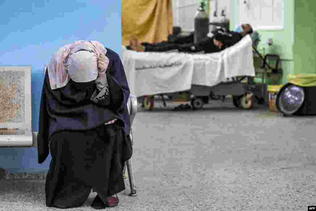 A Palestinian woman reacts while waiting for her husband (background) at the COVID-19 intensive care unit of al-Shifa Hospital in Gaza City.