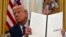 FILE - President Donald Trump holds up an executive order in Washington, Jan. 23, 2025. Since he took office, Trump signed several executive orders, including ones withdrawing the U.S. from the World Health Organization and the Paris Climate Agreement.