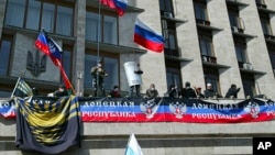 Warga pro Rusia di kota Donetsk Ukraina timur menduduki gedung-gedung pemerintah dan mengibarkan bendera Rusia, Senin (7/4). 