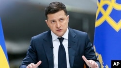 FILE - Ukrainian President Volodymyr Zelenskiy gestures while speaking to the media during a news conference at the Antonov aircraft factory in Kyiv, Ukraine, May 20, 2021.