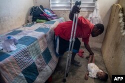 Boulva Verly, 34, tends to his son Woodyna Verly, 3, at their in Croix des Bouquets, 12.9kms (8 miles) to the northeast of Port-au-Prince, on Jan. 2, 2020.