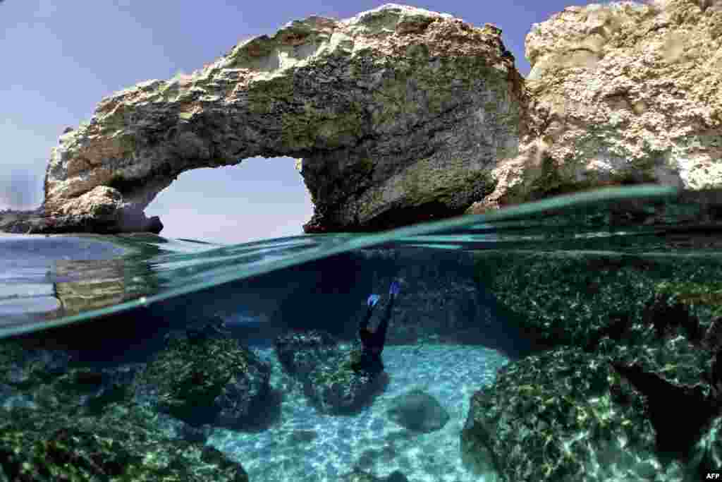 Cypriot marine ecologist Louis Hadjioannou dives to photograph the coral as he monitors the impact of climate change in the crystal clear waters of Glyko Nero in Ayia Napa, off the island&#39;s southeastern shore, Cyprus.