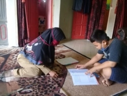 Seorang anak yang sedang belajar di rumah dengan didampingi seorang guru kunjung di desa Malei, Kecamatan Balaesang Tanjung. (Foto: Save The Children Indonesia)