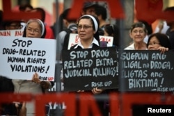 FILE - Catholic nuns hold placards as they protest against what organizers say are drug-related extrajudicial killings, during International Human Rights Day in Manila, Philippines, Dec. 10, 2016.