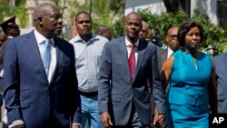 FILE - Haiti's President Jovenel Moise, center, walks with first lady Martine Moise and his Defense Minister Herve Denis, left, during a ceremony presenting the leadership of the newly reinstated Haitian Armed Forces (FAd'h) in Port-au-Prince, Haiti.