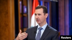 FILE - Syria's President Bashar al-Assad speaks during an interview with Fox News channel in Damascus, in this handout photograph distributed by Syria's national news agency SANA.