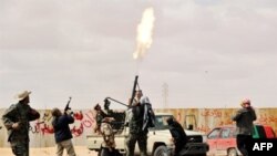 Libyan rebel fighters fire an anti-aircraft weapon at an airforce jet loyal to Qadhafi. (file)