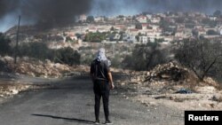 이스라엘이 점령한 요르단강 서안 지구 유대인 정착촌 앞에서 지난달 22일 팔레스타인인 남성이 시위하고 있다. 