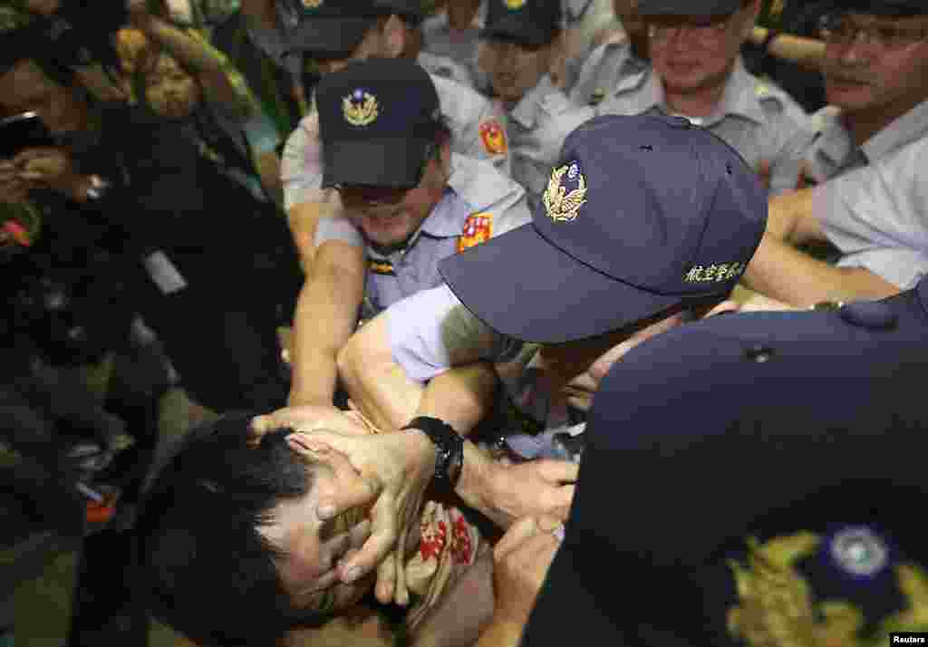 A pro-democracy activist scuffles with police officers while China's top official in charge of relations with Taiwan Zhang Zhijun (not pictured), arrives at the Taoyuan International Airport, northern Taiwan.