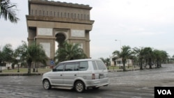 Kendaraan melintas di Simpang Lima Gumul, Kediri, dengan jalanan yang tertutup pasir material letusan gunung Kelud setebal 5 cm, 15 Februari 2014 (VOA/Petrus Riski).