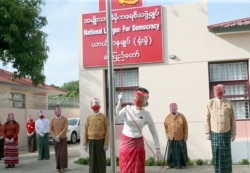 Pemimpin Myanmar Aung San Suu Kyi mengibarkan bendera partai Liga Nasional Untuk Demokrasi dalam sebuah upacara untuk menandai hari pertama kampanye pemilihan umum di markas sementara partai di Naypyitaw, Myanmar pada Selasa, 8 September 2020. (Foto: AP)