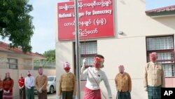 Pemimpin Myanmar Aung San Suu Kyi mengibarkan bendera partai Liga Nasional Untuk Demokrasi dalam upacara untuk menandai hari pertama kampanye pemilu di markas sementara partai di Naypyitaw, Myanmar pada Selasa, 8 September 2020. (Foto: AP)