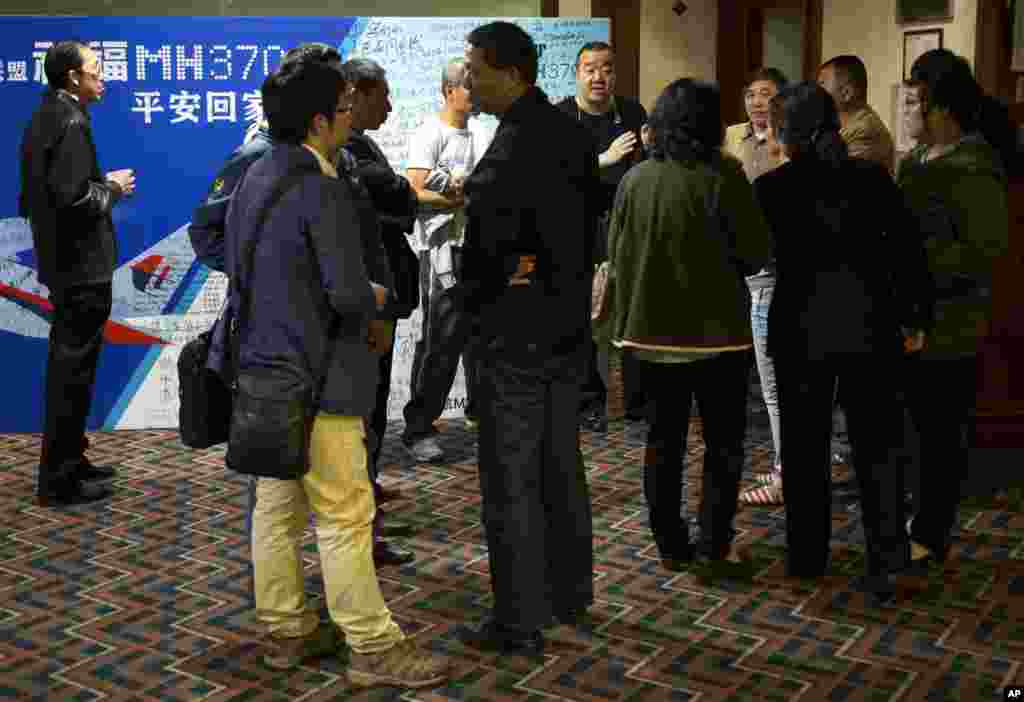 Kerabat para penumpang penerbangan MH370 menunggu kabar di luar ruang konferensi di sebuah hotel di Beijing (11/4). (AP/Andy Wong)