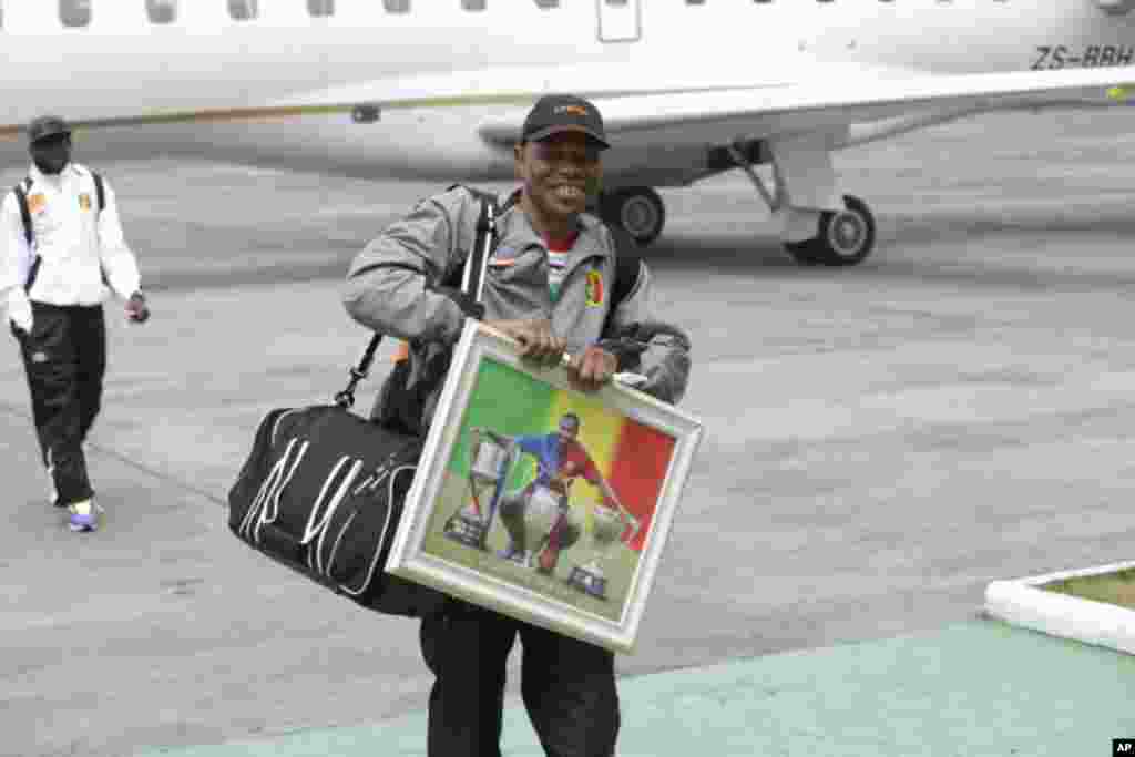 Un membre de la délégation malienne porte un portrait de la star du football malien Seydou Keita à l&#39;arrivée à l&#39;aéroport international de Malabo à Malabo, Guinée équatoriale vendredi 16 janvier 2015.