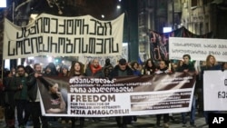 Protesters hold banners calling for the release of jailed journalist Mzia Amaghlobeli as they march through the streets in Tbilisi, Georgia, on Jan. 29, 2025.