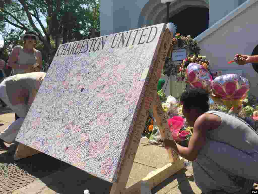 Papan &#39;Charleston Bersatu&#39; berisikan tanda tangan terlihat di luar Gereja AME Emanuel di Charleston, South Carolina (21/7). (VOA/Amanda Scott)