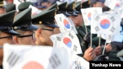 23일 서울 전쟁기념관에서 열린 연평도 포격도발 전사자 2주기 추모식에서 태극기를 흔드는 해병대 장병들.