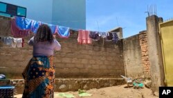 FILE - Reby hangs laundry outside her home in Beni, eastern Congo, May 1, 2021. Reby has accused a member of the World Health Organization of sexual exploitation.