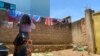 FILE - Reby hangs laundry outside her home in Beni, eastern Congo, May 1, 2021. Reby has accused a member of the World Health Organization of sexual exploitation.