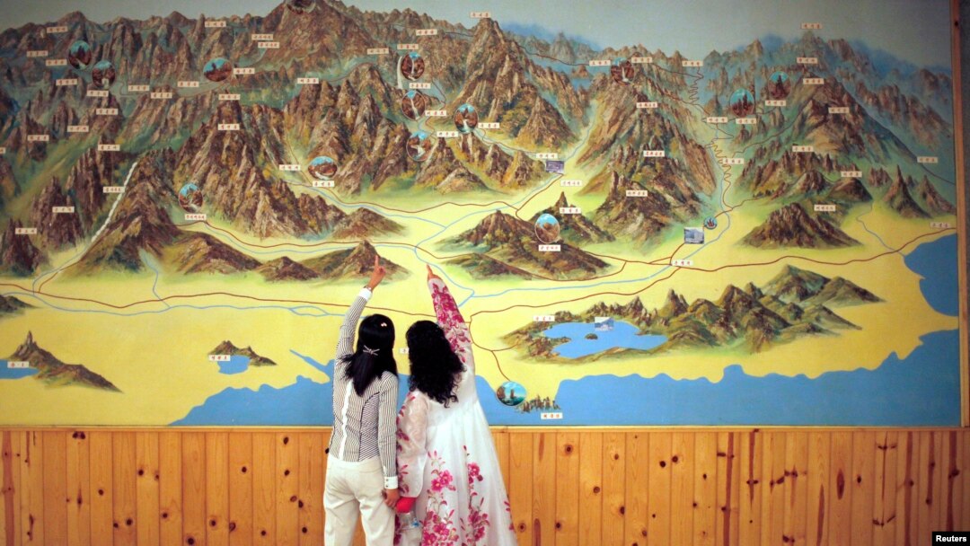 FILE - People point to a map on a wall in Mount Kumgang resort in Kumgang, Sept. 1, 2011. 
